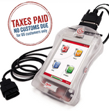 A handheld electronic device with a cable, presumably a car diagnostic tool, displayed in a clear plastic case.